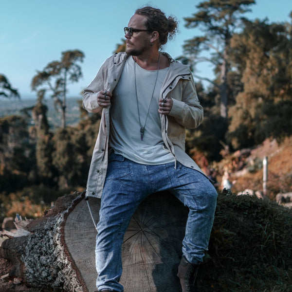 Man sitting on a log in a forested area