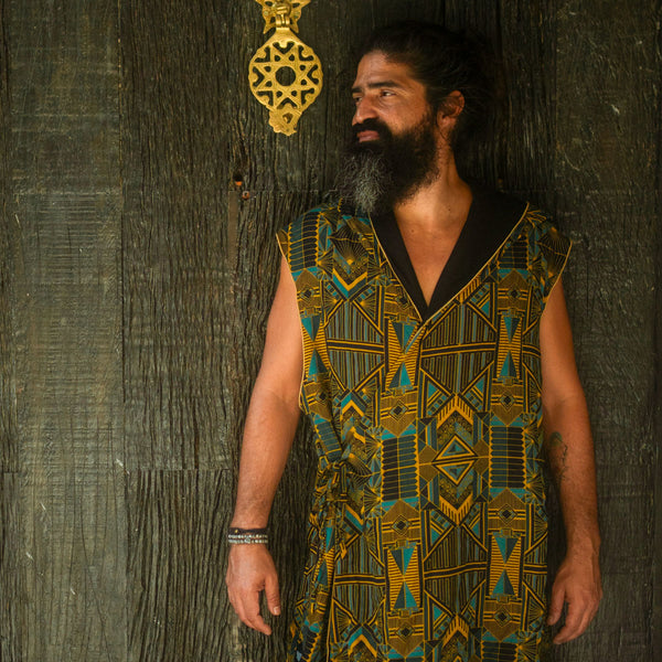 Man wearing a patterned vest against a textured dark background